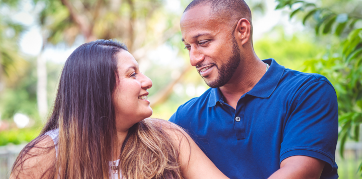 Man and woman sitting together outdoors and looking at each other